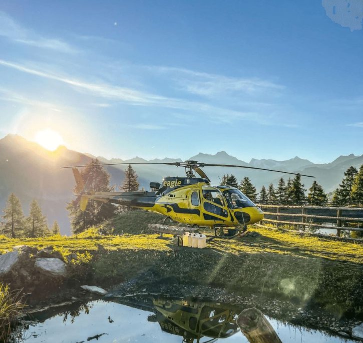Hélicoptère posé à côté d'un lac, pour un ravitaillement d'essence.