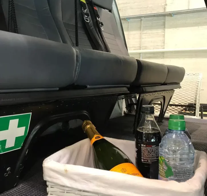 Intérieur d'un AS350B3 avec un panier cadeau contenant du champagne.
